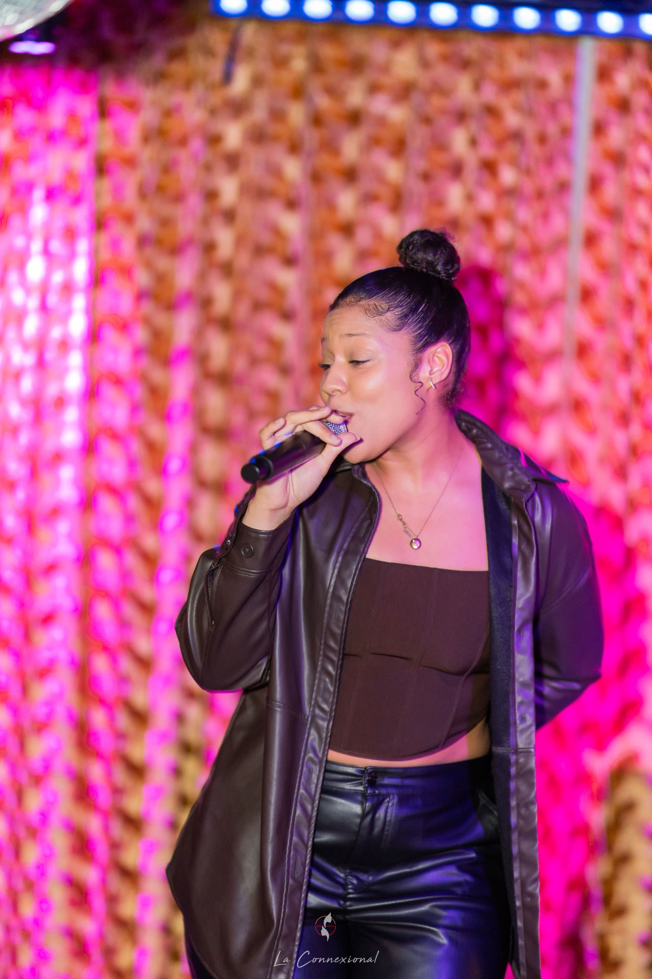 Ezeada performing beneath warm pink stage lighting